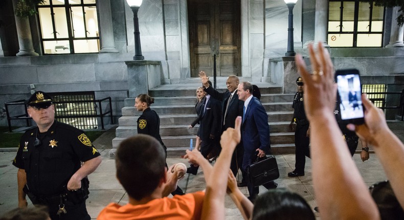 Bill Cosby waves to people calling out to him as he walks from the Montgomery County Courthouse during his sexual assault trial in Norristown.