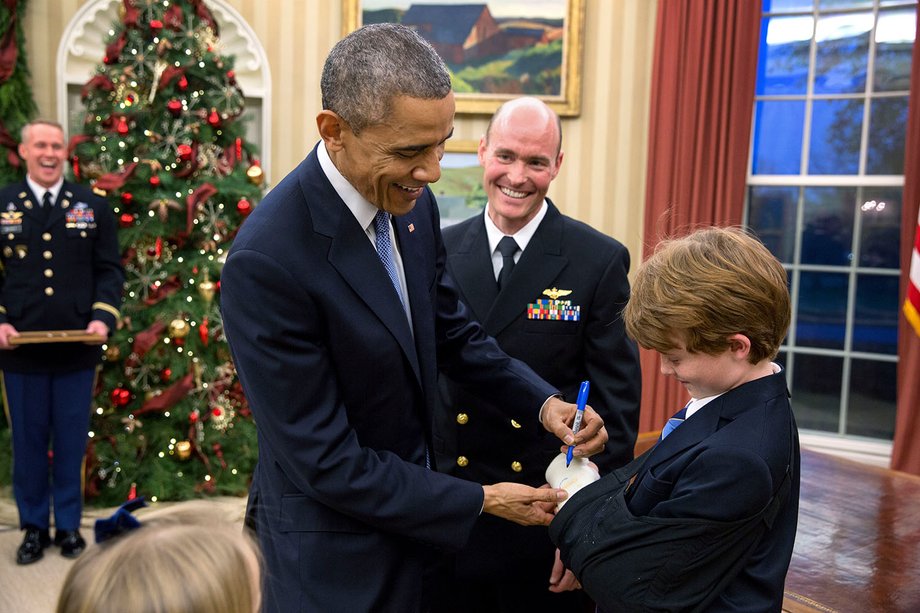 Prezydent Barack Obama podpisuje się na gipsie Braydena Myersa podczas ceremonii promocyjnej jego ojca porucznika Timothy'ego J. Meyersa