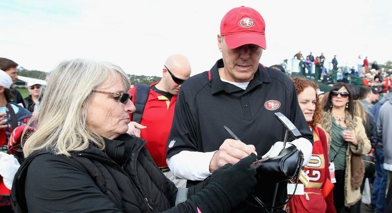 Former San Francisco 49ers wide receiver Dwight Clark signs autographs for fans during the 4th Annual Chevron Charity Shoot-Out at Pebble Beach Golf Links in California, in 2014