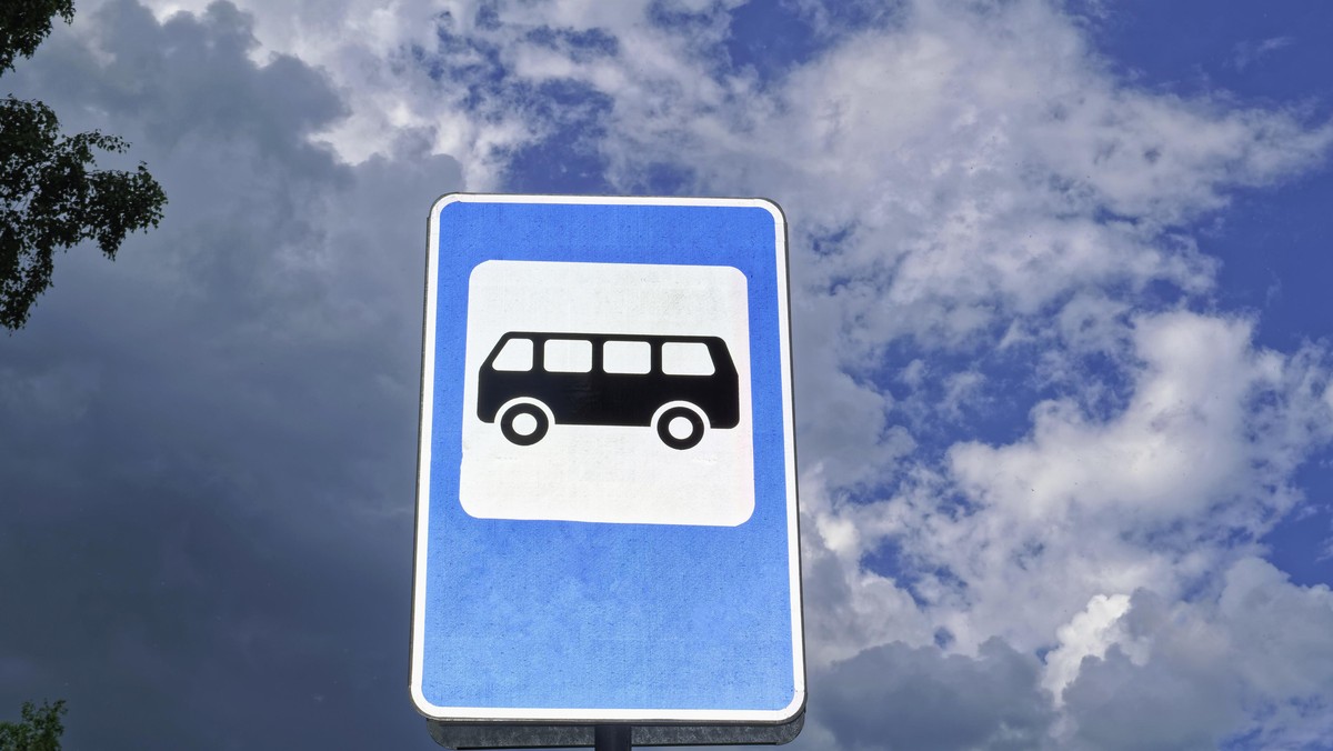 Bus stop road sign on background of blue sky.