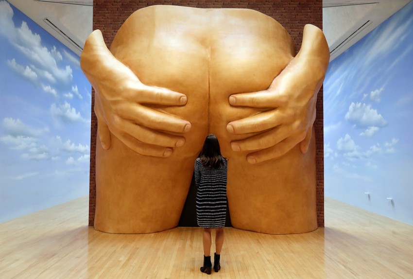 Žena posmatra skulpturu muške zadnjice, rad Antee Hamilton
