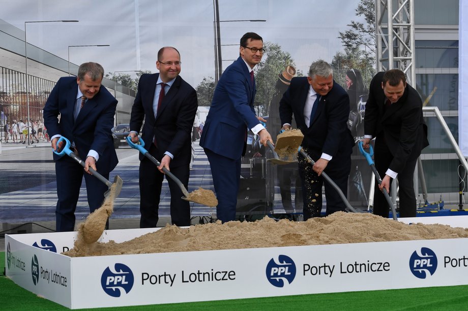 Mariusz Szpikowski (PPL), Adam Bielan (PiS), Mateusz Morawiecki, Marek Suski (PiS) i Mikołaj Wild (MI) przesypują piasek podczas inauguracji budowy od nowa lotniska w Radomiu