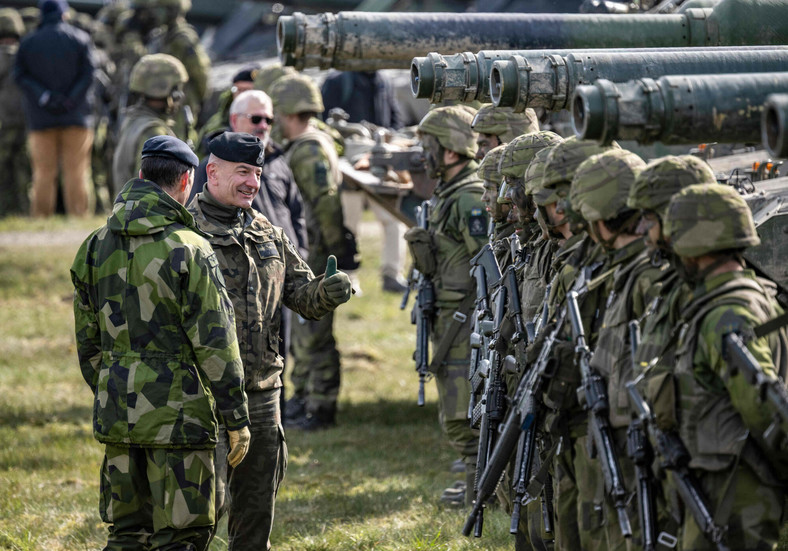 Naczelny Dowódca Wojsk Lądowych Szwecji Micael Byden (po lewej) oraz Szef Sztabu Generalnego Wojska Polskiego Rajmund Andrzejczak (w środku) instruują załogi czołgów podczas ćwiczeń wojskowych Aurora 23 na poligonie Rinkaby pod Kristianstad w Szwecji, 6 maja 2023 r.