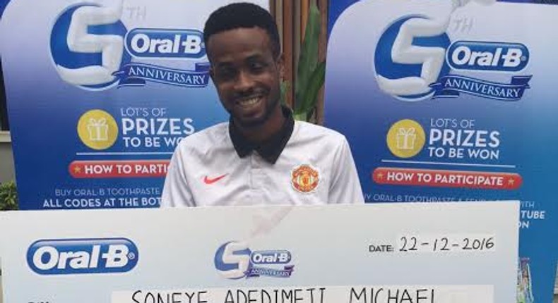 Soneye Adedimeji Michael Grand Prize Winner of the Oral B National Consumer Promo, with his cheque of N300,000.