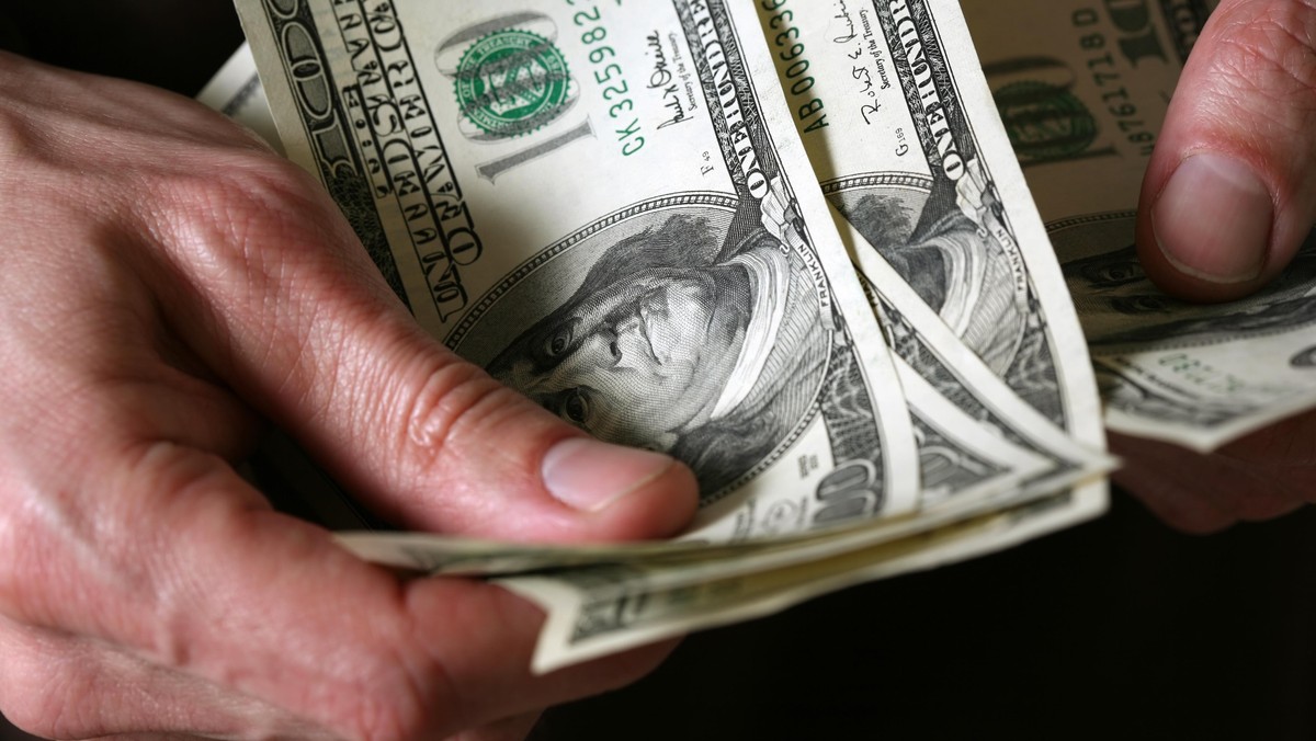 Man's hands hold dollars banknotes money