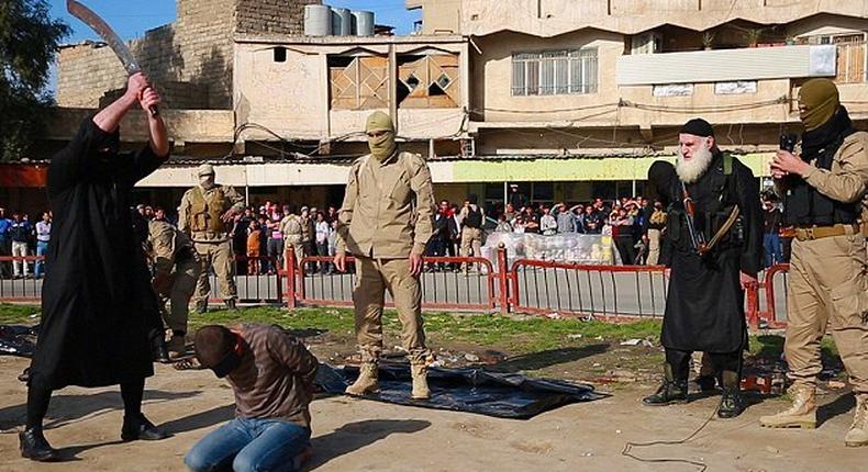 The executioner stands with the sword poised above the man's head as a large crowd gathers to watch