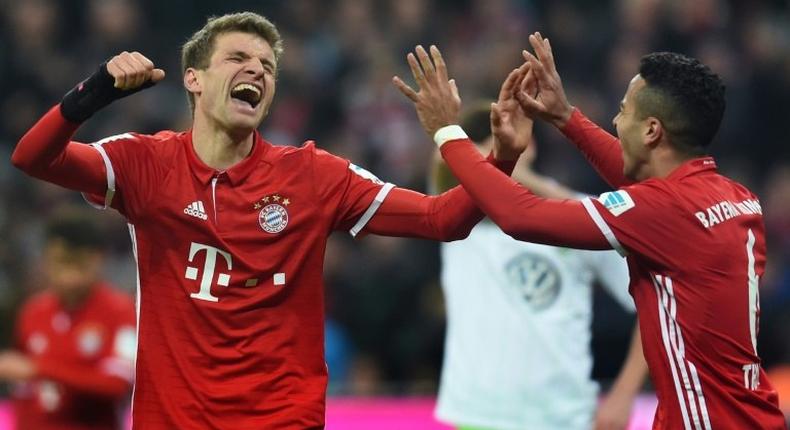 Bayern Munich's Thomas Mueller (L) and Thiago Alcantara (R) celebrate after the third goal for Munich against Wolfsburg on December 10, 2016