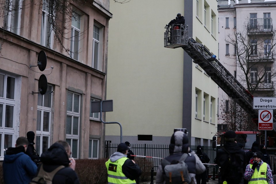 Policjanci zaglądający ze strażackiego podnośnika do mieszkania wynajętego przez działaczy Lotnej Brygady Opozycji