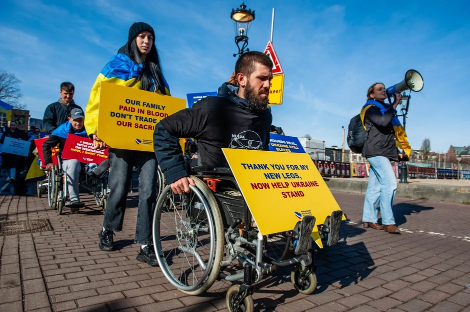 Ukrajinski vojnik koji je ostao bez nogu predvodi marš tokom demonstracija u Amsterdamu 23. februara 2025.