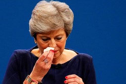 Britain's Prime Minister Theresa May wipes her nose after she suffered a coughing fit whilst addressing the Conservative Party conference in Manchester