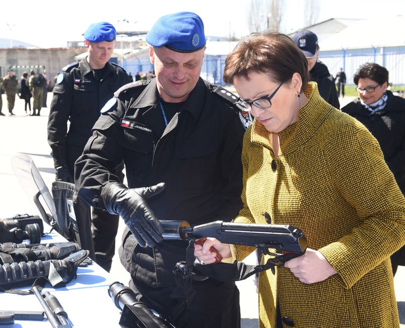 Dowódca jednostki, nadkomisarz Krzysztof Janiszewski, prezentujący elementy uzbrojenia policjantów.