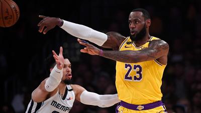 Los Angeles Lakers forward LeBron James, right, passes while under pressure from Memphis Grizzlies guard Dillon Brooks during the first half of an NBA basketball game Friday, Feb. 21, 2020, in Los Angeles. (AP Photo/Mark J. Terrill)
