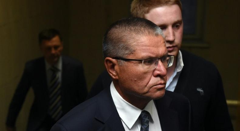 Russia's Economy Minister Alexei Ulyukayev, charged by the Investigative Committee with bribe-taking, is escorted before a hearing at the Basmanny district court in Moscow on November 15, 2016