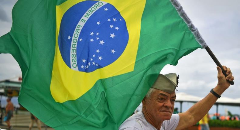 A supporter of President Jair Bolsonaro waves a Brazilian flag during a demonstration in support of the ultraconservative government as it faces growing opposition