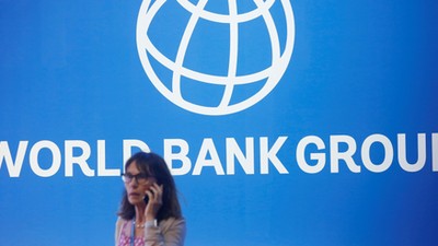 FILE PHOTO: A participant stands near a logo of World Bank at the International Monetary Fund - World Bank Annual Meeting 2018 in Nusa DuaReuters