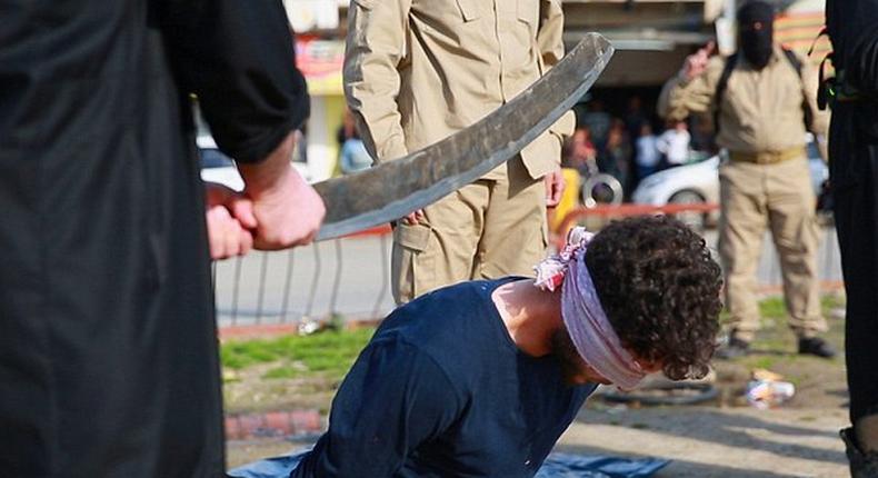 One of the blindfolded victims kneels with his head forward immediately prior to the beheading. Messages accompanying the images claimed two men were accused of homosexuality and a third of blasphemy