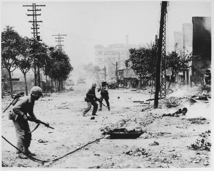 Amerykańscy marines w czasie walk miejskich w Seulu. Żołnierz na pierwszym planie jest uzbrojony w karabin M1 Garand, na drugim planie w karabin maszynowy Browning M1918, a w tle widoczny czołg M4 Sherman