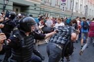 Police officers chase protesters during a rally against planned increases to the nationwide pension 