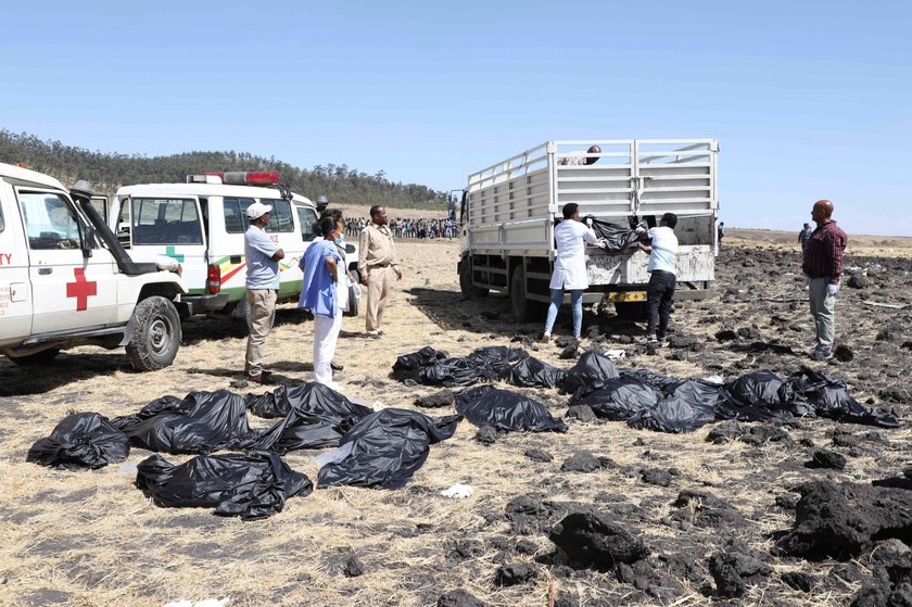 People walk at the scene of the Flight ET 302 plane crash, near the town of Bishoftu