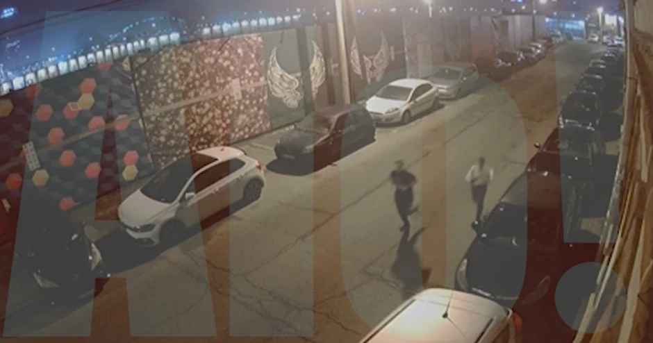 Nekoliko sekuni kasnije se bolje vidi mladić u majici kratkih rukava, ali sada izgleda da nosi crne patike sa belim đonom. S njim trči ženska osoba u belom džemperu, bundi ili jakni