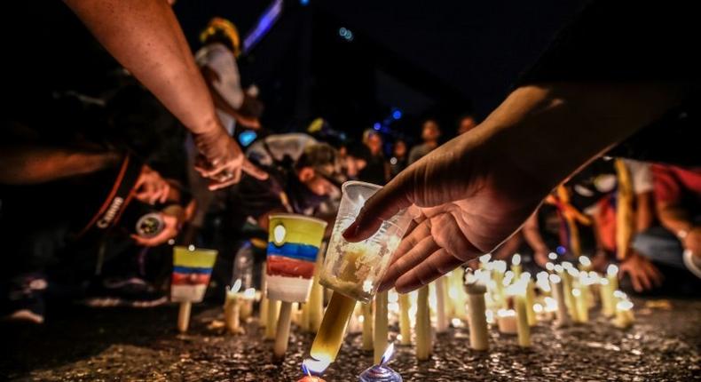 Opposition activists place candles to protest against the deaths of 43 people in clashes with the police during weeks of anti-government demonstrations