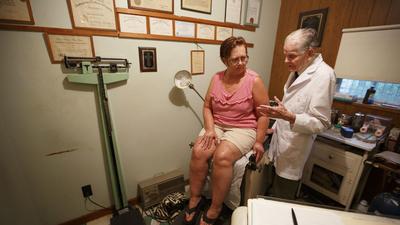 Dr. Bryon Harbolt examines patient Barbara Kilgore in his Cathedral Canyon Clinic in Altamont