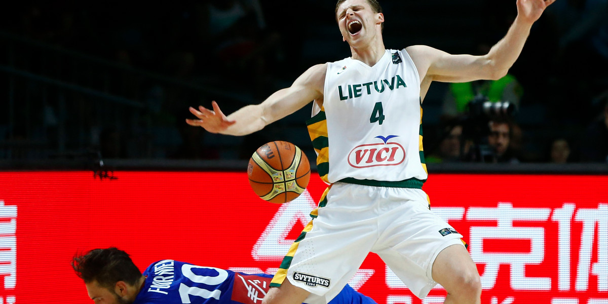 France's Evan Fournier (L) falls as he fights for the ball with Lithuania's Martynas Pocius during their Basketball World Cup third place game in Madrid September 13, 2014.