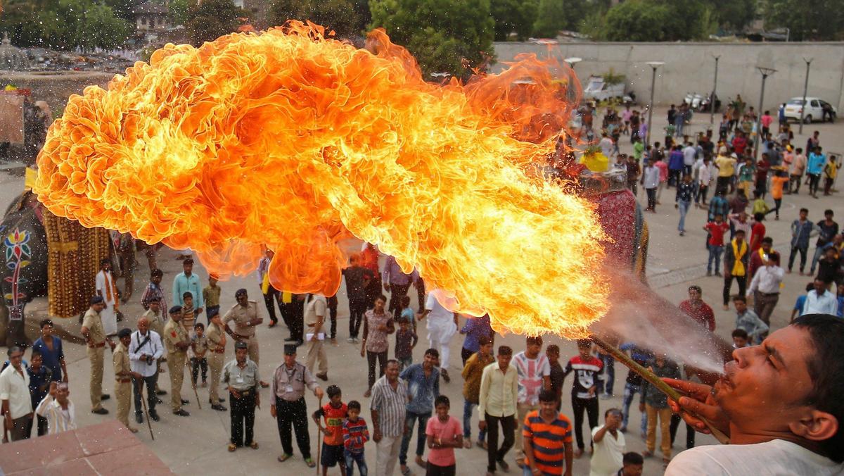 A Hindu devotee performs a stunt with fire during the Jal Yatra procession ahead of the annual Rath Yatra, or chariot procession, which will be held on June 25, in Ahmedabad