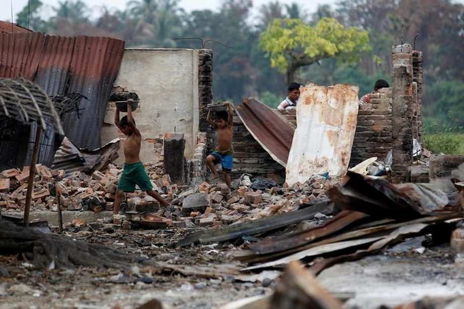 FILE PHOTO: Children recycle goods from the ruins of a market which was set on fire at a Rohingya village outside Maugndaw in Rakhine state