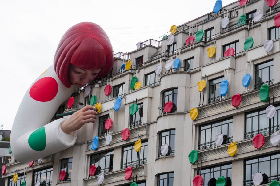 Japońska artystka Yayoi Kusama przedstawiona na swojej własnej rzeźbie na dachu sklepu Louis Vuitton na Polach Elizejskich w Paryżu