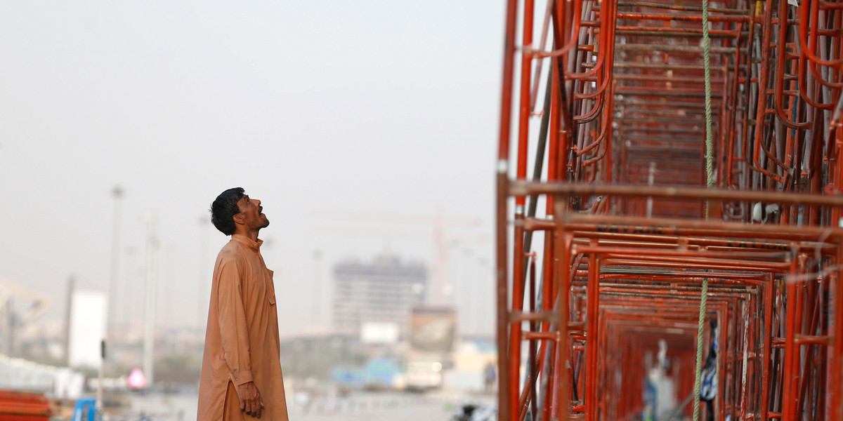 An Indian labourer looks at the construction site of a building in Riyadh November 16, 2014. India is pressing rich countries in the Gulf to raise the wages of millions of Indians working there, in a drive that could secure it billions of dollars in fresh income but risks pricing some of its citizens out of the market. Picture taken November 16.
