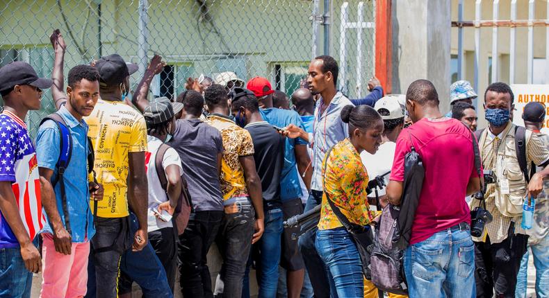 Haitian migrants flown out of Texas by US authorities wait outside of Toussaint Louverture International Airport in Port-au-Prince, Haiti.
