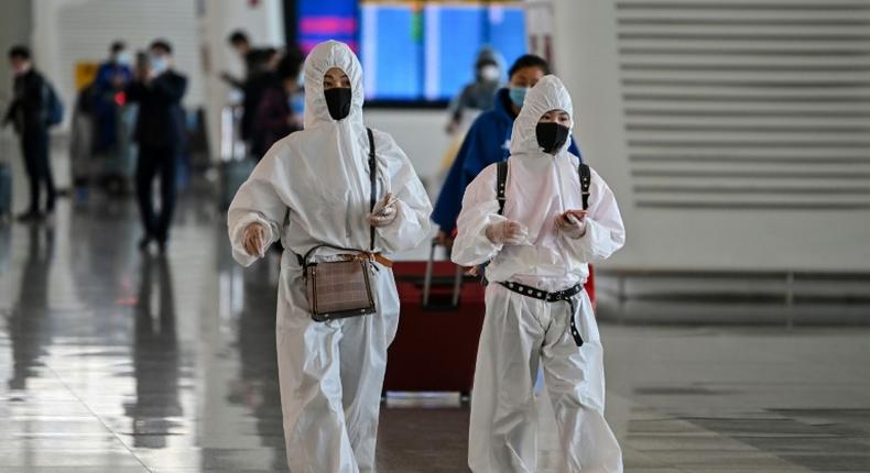 Passengers in protective gear walk through Tianhe Airport after it was reopened in Wuhan in China's central Hubei province