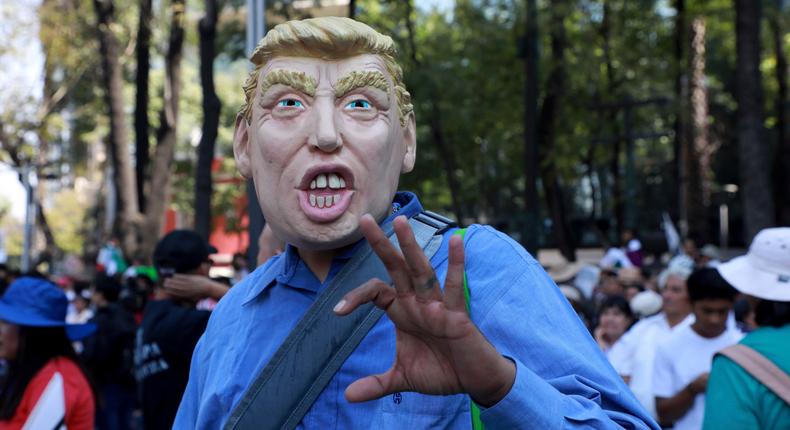 A man in a mask depicting US President Donald Trump at a march demanding respect for Mexico and its migrants, in Mexico City, February 12, 2017.