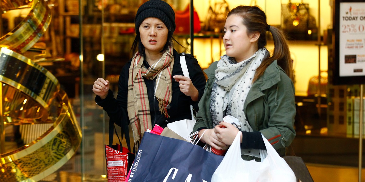 Shoppers walk with bags at Somerset Collection shopping mall in Troy, Michigan.