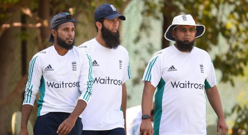 England players Adil Rashid (L) and Moeen Ali head for a training session with bowling coach Saqlain Mushtaq (R)