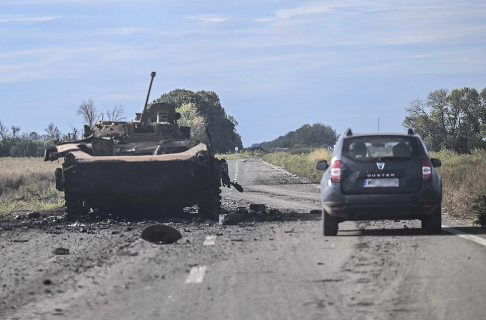 Samochód z polską rejestracją przejeżdża obok zniszczonego rosyjskiego czołgu w miejscowości Bałaklija.