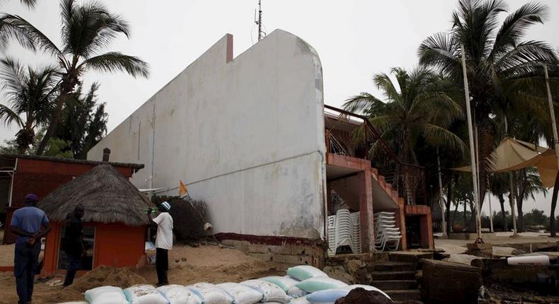 Hotel employees stand in front of sandbags protecting the hotel's beach in Saly, Senegal, November 12, 2015. To match CLIMATECHANGE-SUMMIT/AFRICA. REUTERS/Makini Brice