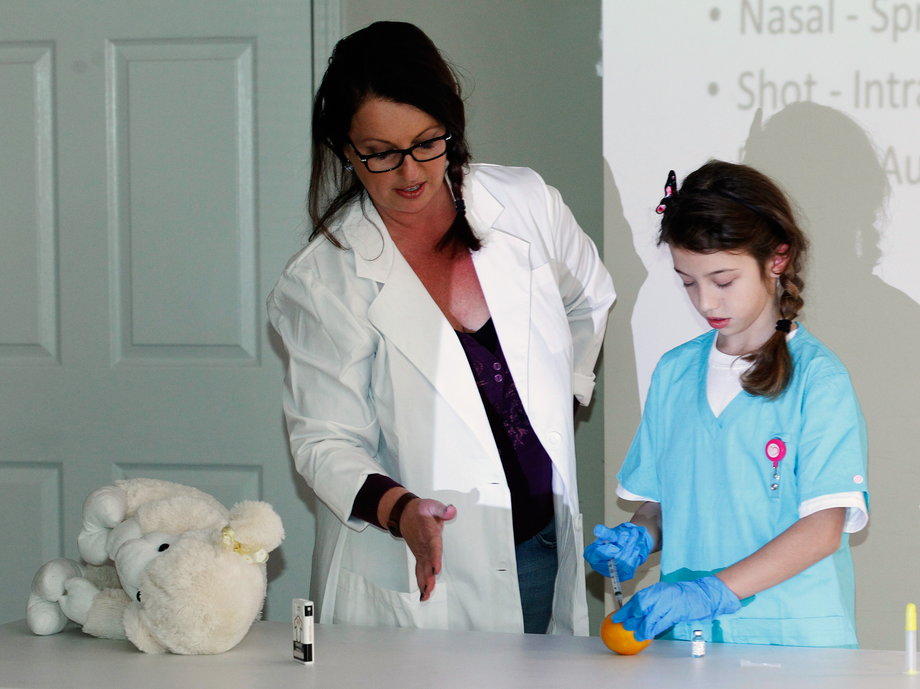 Jennifer Stepp, left, and her daughter teach a naloxone training class for children and adults on how to save lives by injecting the drug into people suffering opioid overdoses.