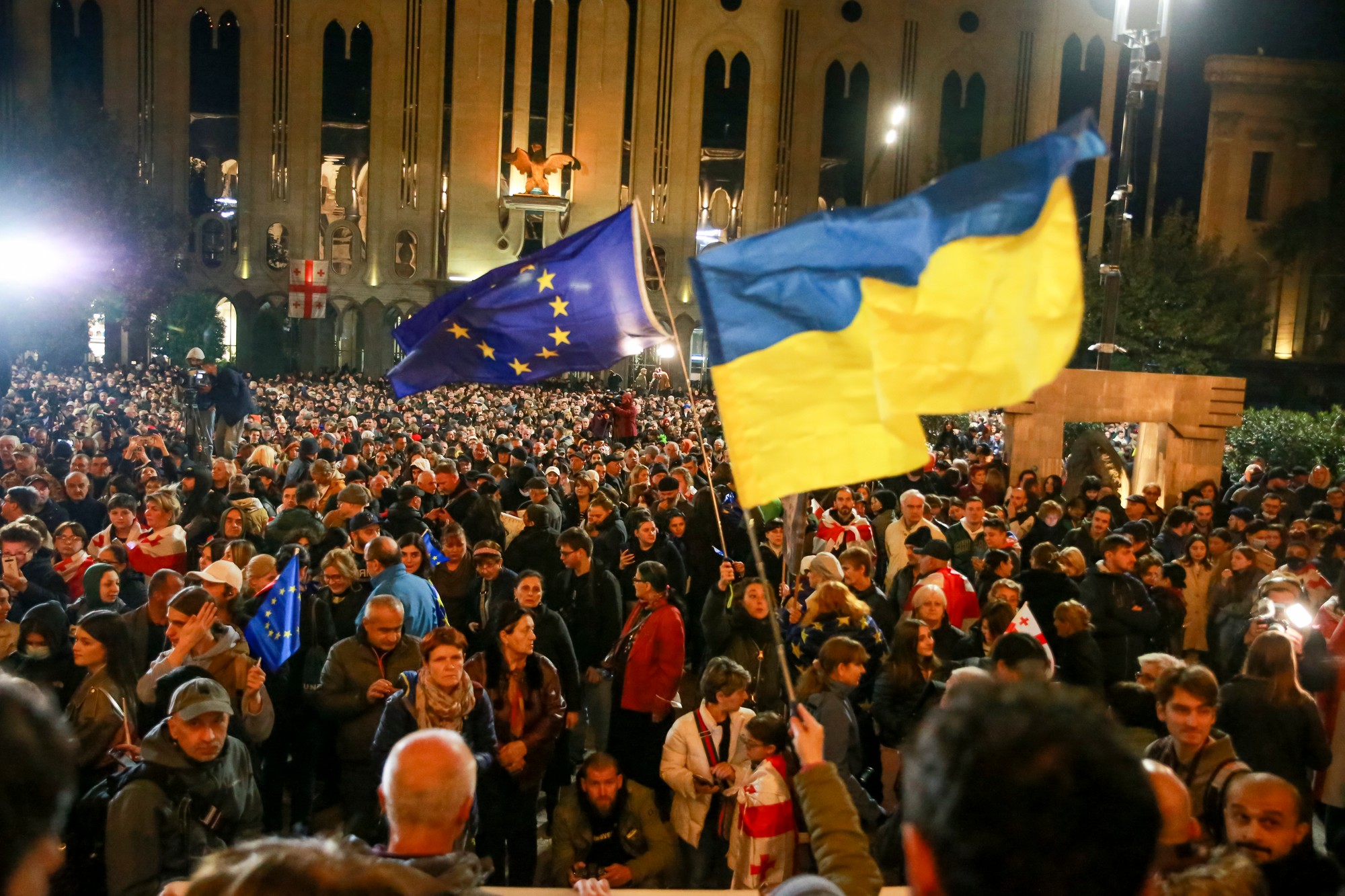 Demonštranti mávajú vlajkou EÚ a Ukrajiny počas opozičného protestu proti výsledkom parlamentných volieb v gruzínskom Tbilisi.