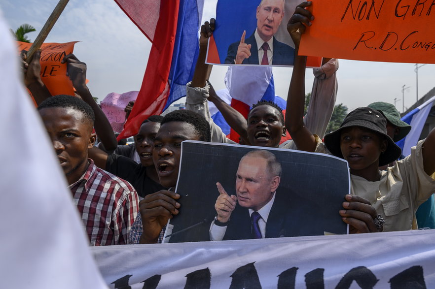 Protestujący machają rosyjskimi flagami i trzymają portret prezydenta Rosji Władimira Putina przed Ambasadą Francji w Kinszasie, 1 marca 2023 r.