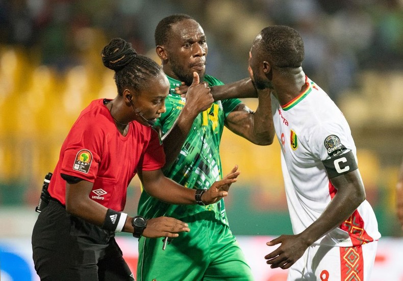 Salima Mukansanga of Rwanda in action as she keeps control between ONISMOR BHASERA of Zimbabwe and NABY KEÏTA of Guinea during a Group B 2021 AFCON match (Photo by Visionhaus/Getty Images)