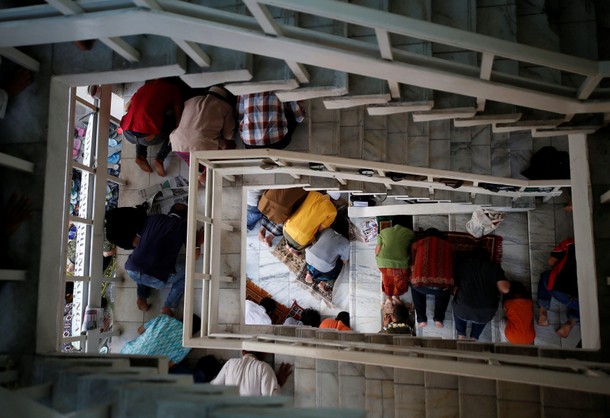 Indonesian Muslims are seen praying in the staircase of a mosque during Friday prayers during the fa