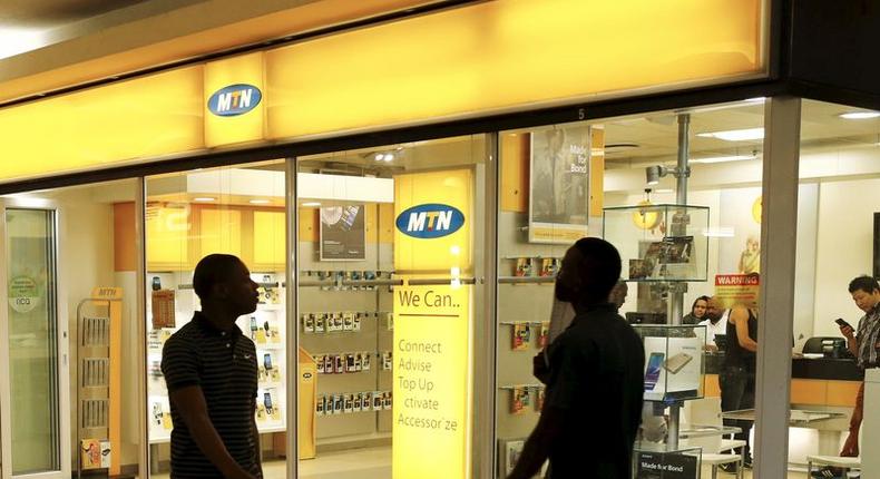 Bystanders walk past an outlet of South Africa's MTN Group in downtown Cape Town, November 10, 2015.   REUTERS/Mike Hutchings