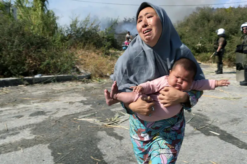 Uchodźczyni ucieka przed kolejnym pożarem na Lesbos, tym razem w pobliżu Mitylene/Fot. AP/Associated Press/East News