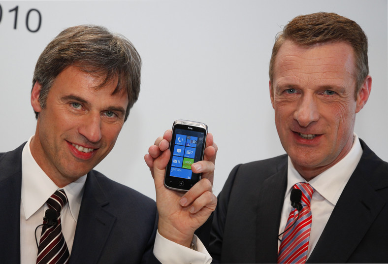 Achim Berg z Microsoft Corp. (z lewej) i Niek Jan van Damme z Deutsche Telekom AG na konferencji prasowej w Hamburgu pozują do z zdjęcie z telefonem High Tech Computer Corp. (HTC) Mozart wyposażonym w najnowszy system operacyjny korporacji Microsoft - Windows Phone 7. Fot. Jochen Eckel/Bloomberg