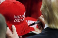 U.S. Republican presidential candidate Trump signs a hat at a campaign rally in West Chester