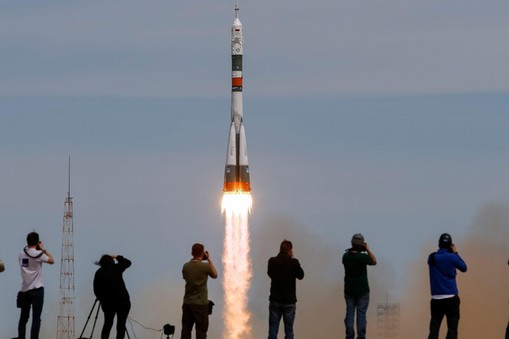 Photographers take pictures as Soyuz MS-04 spacecraft carrying the crew of Fischer of the U.S. and Yurchikhin of Russia as it blasts off to ISS from the launchpad at the Baikonur Cosmodrome