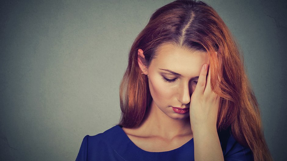 sad young beautiful woman with worried stressed face expression looking down