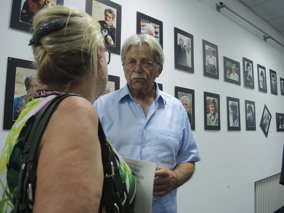 Ljubivoje Ršumović sa svojim radovima u pozadini